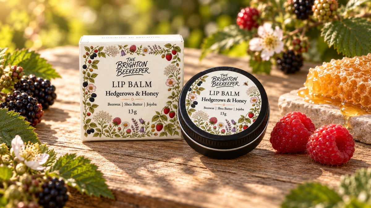 Hedgerows & Honey Lip Balm tin and gift box among raspberries and blackberries