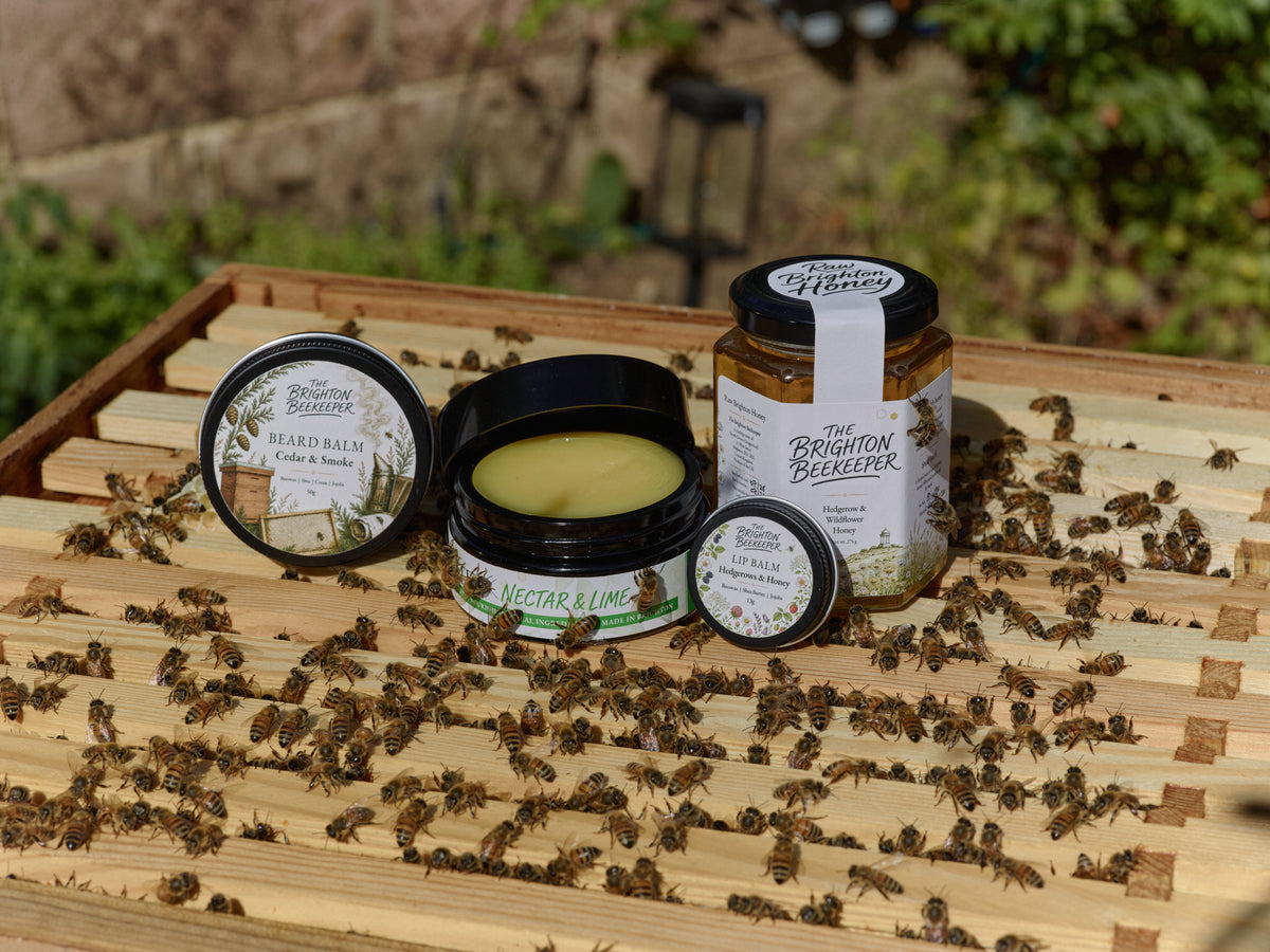 The Brighton Beekeeper beeswax skincare collection on a wooden hive